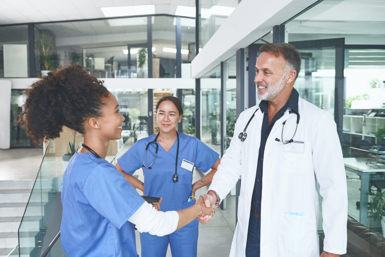 Doctors and nurses shaking hands in hospital