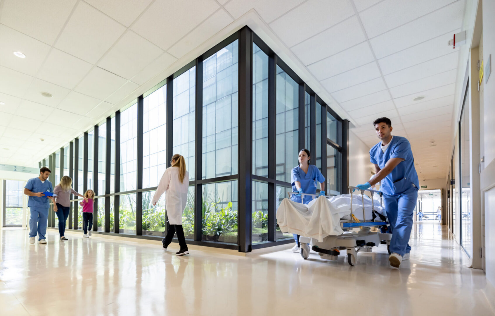 Healthcare professionals moving patient in hallway