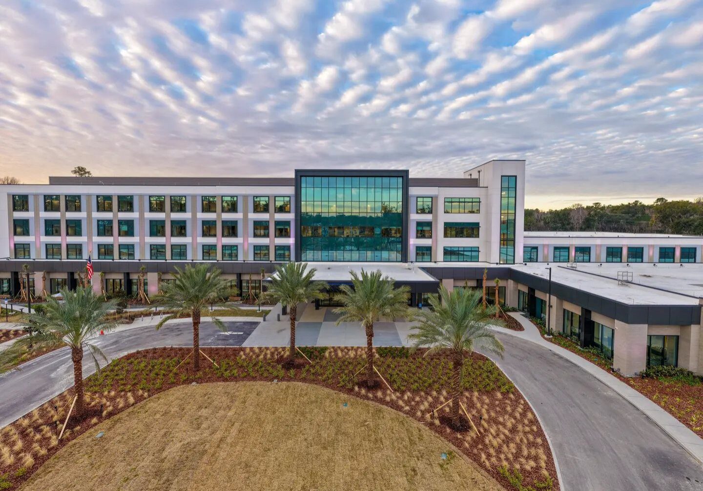 Large glass-fronted building with landscaped entrance